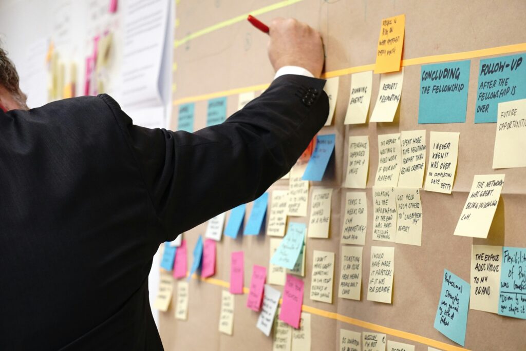 Person putting sticky notes on a wall.